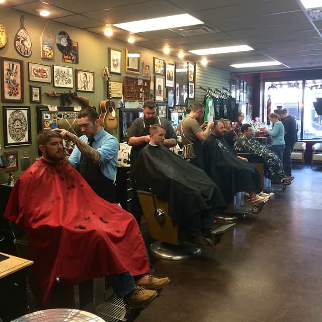 Barbers at work — art-covered walls and guitar on display