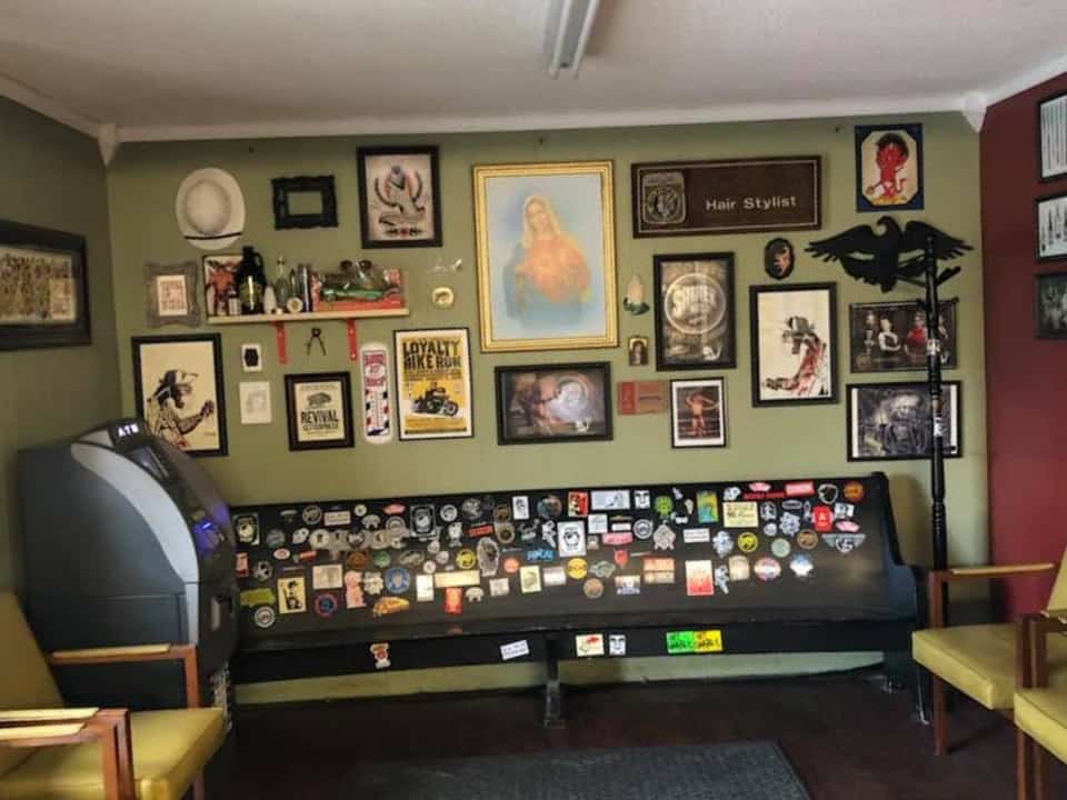 Archbald waiting area — sticker-covered church pew and gallery wall